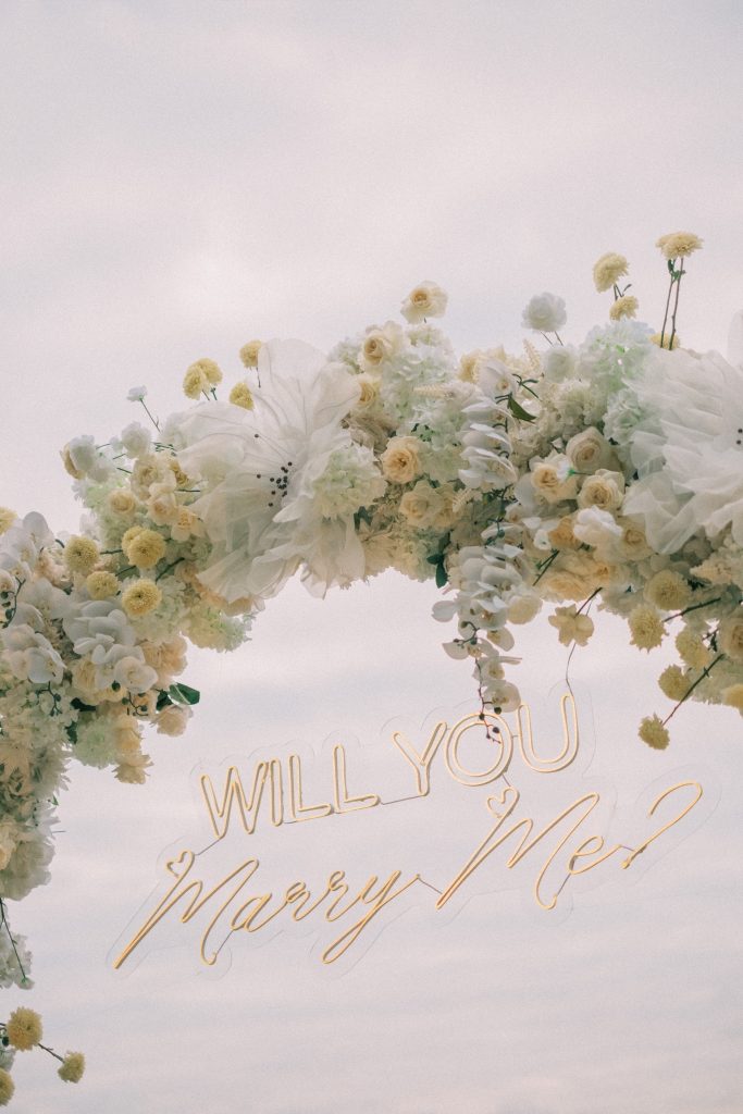 Baby's breath details around floral proposal arch